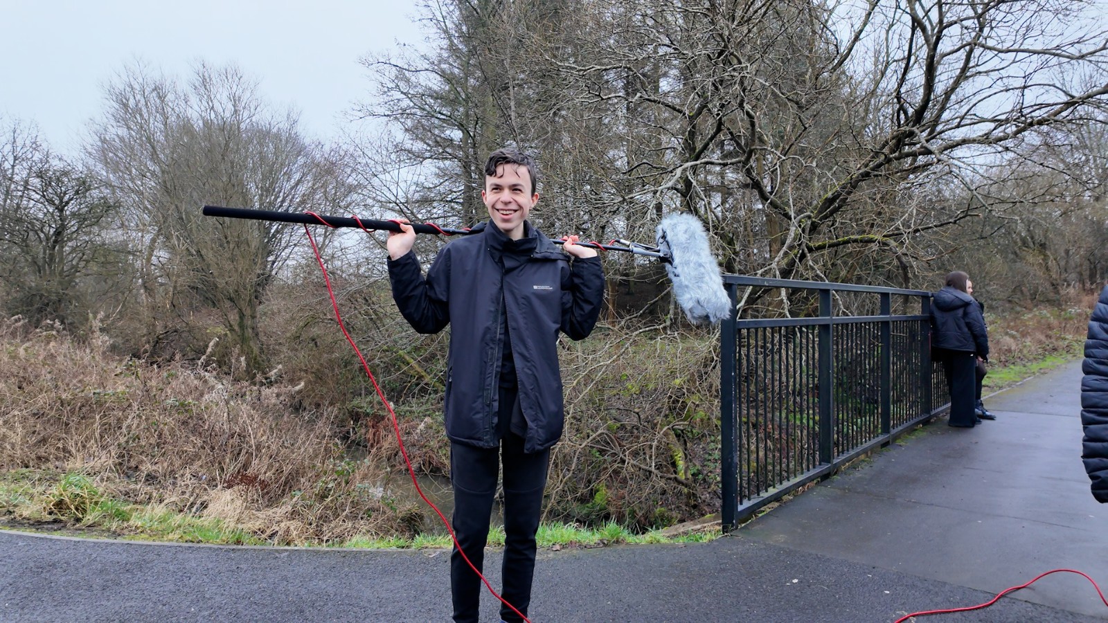 One of the attendees of the Police Scotland Youth Volunteers screen education programme in Dunfermline. They wear all black and hold a boom mic