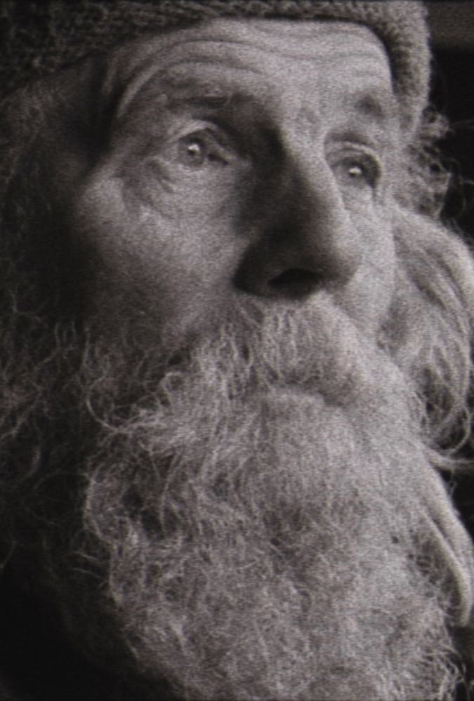 Still from Bogancloch, which shows a black and white image of the close up of a man's face. He has a beard and long hair.