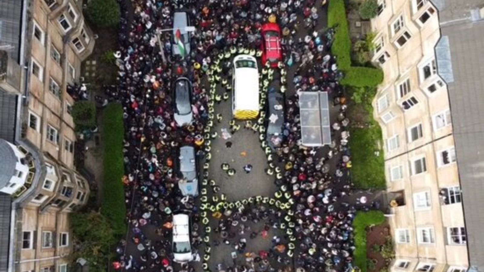 Aerial shot of a street in Glasgow from above, filled with people and vehicles