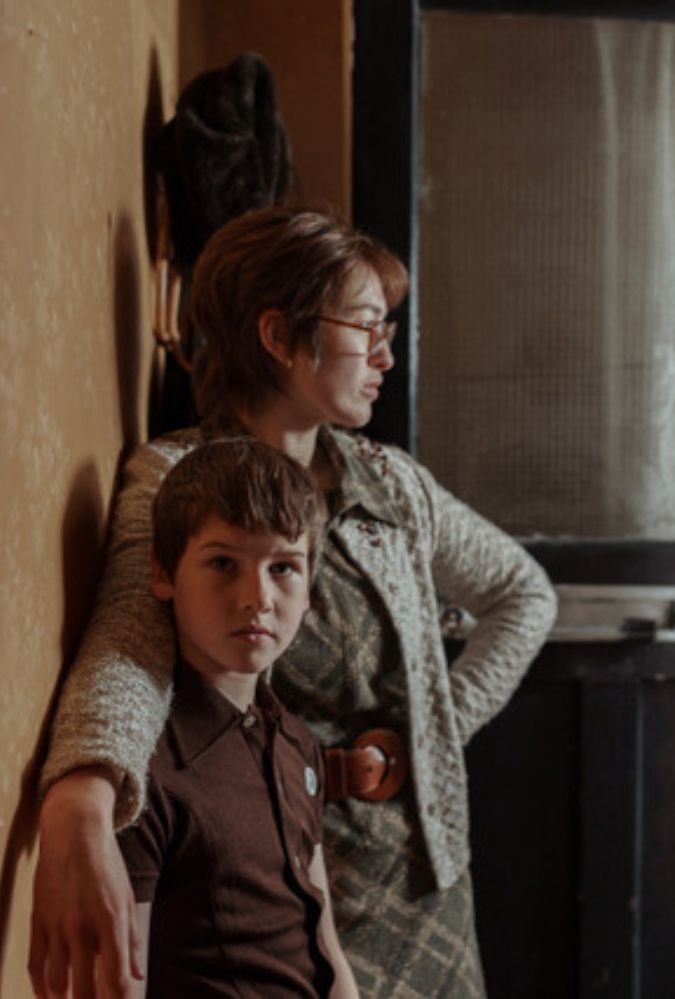 Still from Spilt Milk showing actors Cillian Sullivan and Danielle Galligan, who stand indoors looking out of an open front door of a house.