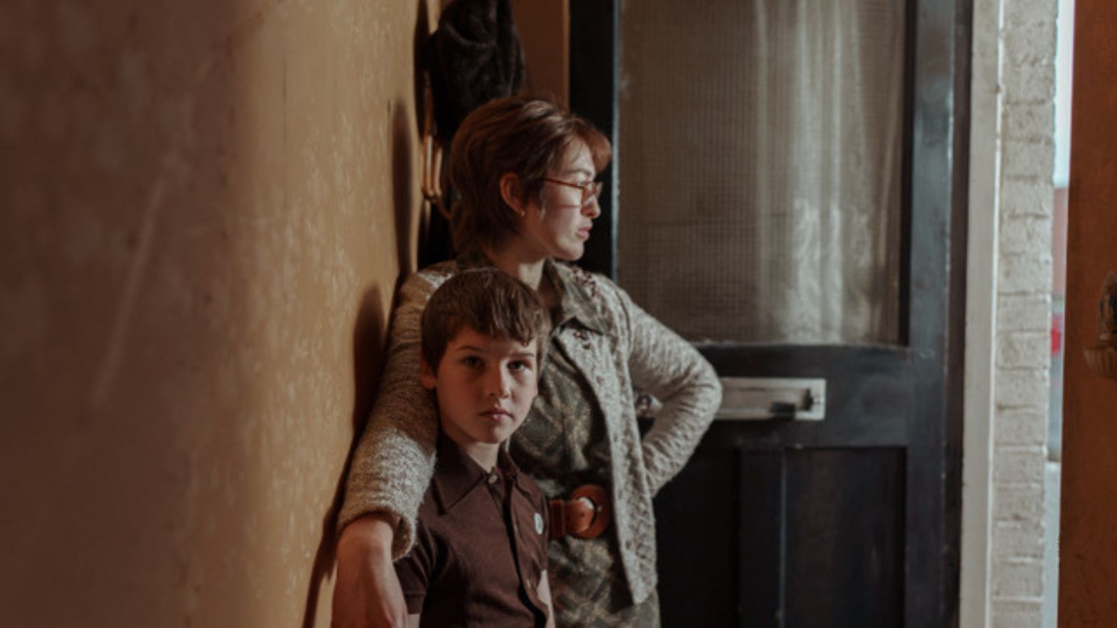 Still from Spilt Milk showing actors Cillian Sullivan and Danielle Galligan, who stand indoors looking out of an open front door of a house.