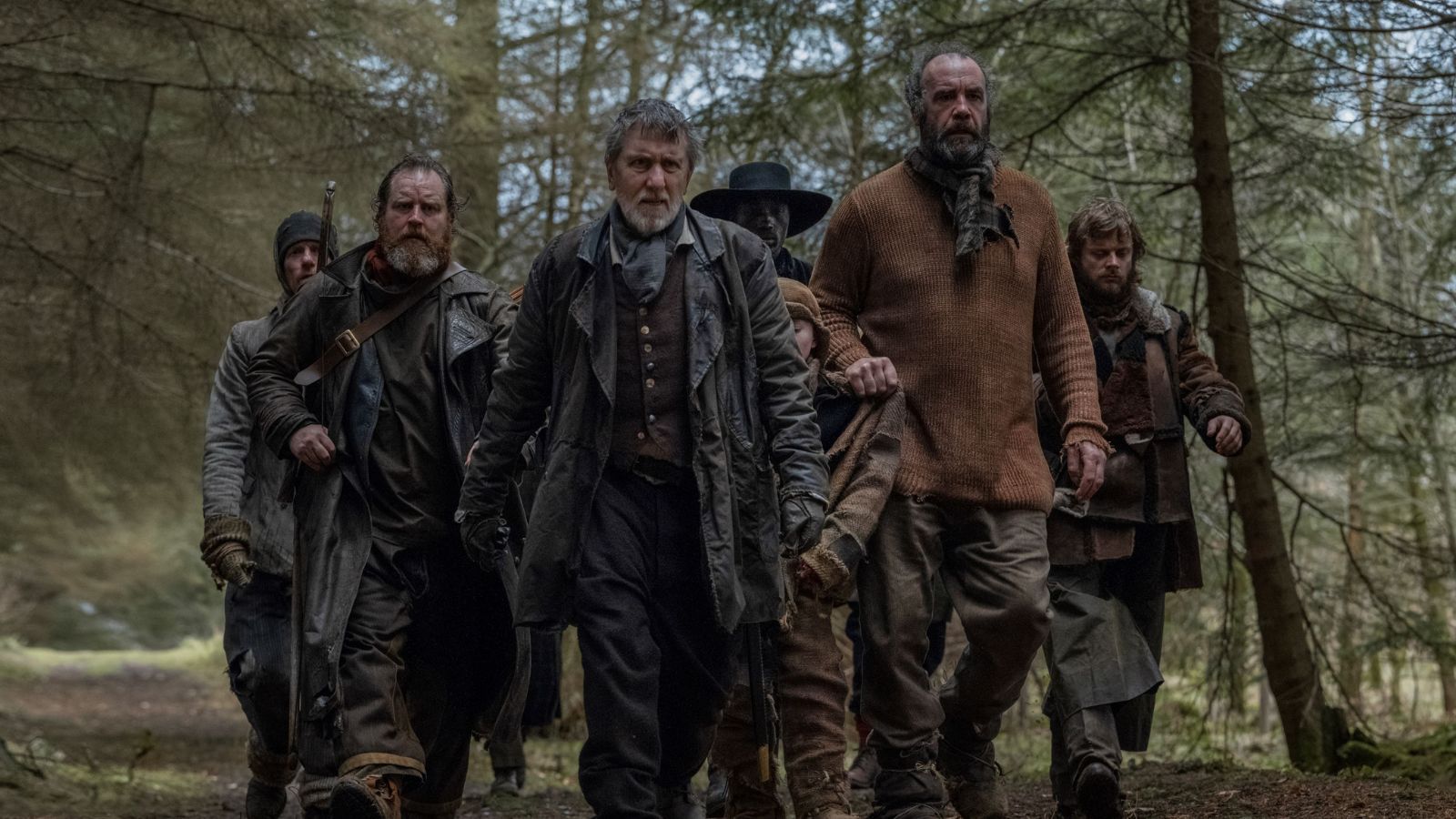 Still from Tornado, which shows seven men, including actor Tim Roth, in 1790s clothing walking through a forest