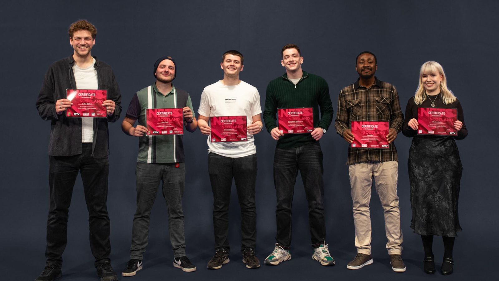 The six 2024 Scottish Broadcast trainees stand in a row holding their certificates up. Credit Ocean Teal.