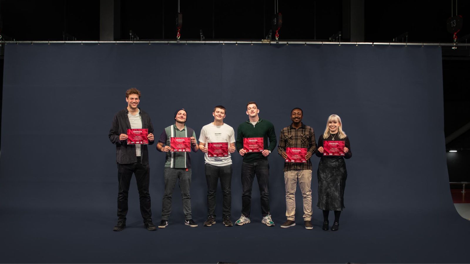 The six 2024 Scottish Broadcast trainees stand in a row holding their certificates up. Credit Ocean Teal.